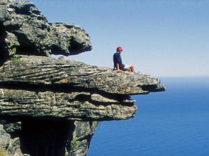 Person on a rocky mountain with a large drop