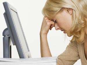 Exhausted and frustrated woman at a computer