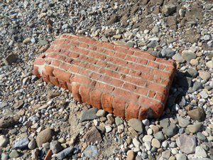 Part of a brick wall lying on a beach